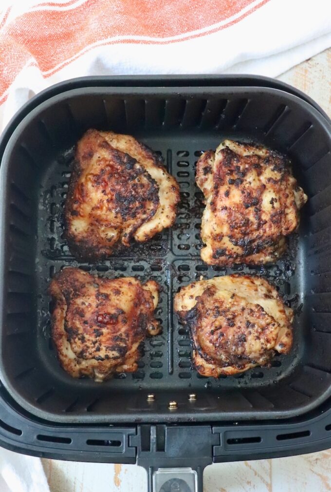 cooked bone-in chicken thighs in air fryer basket
