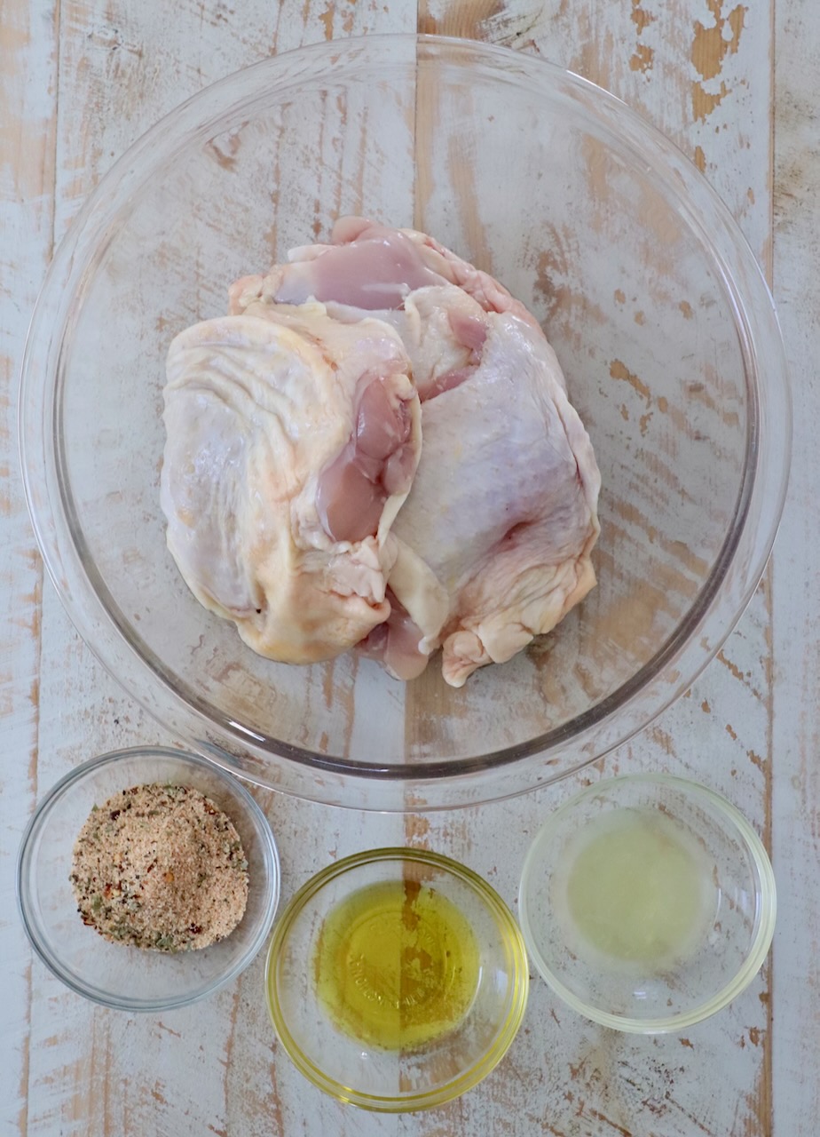 ingredients for air fryer chicken thighs on white wood board