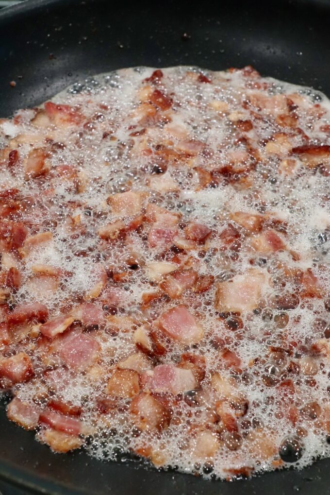 diced bacon frying in skillet