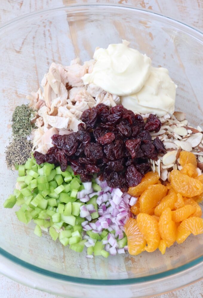 all ingredients for chicken salad separated in a large glass bowl