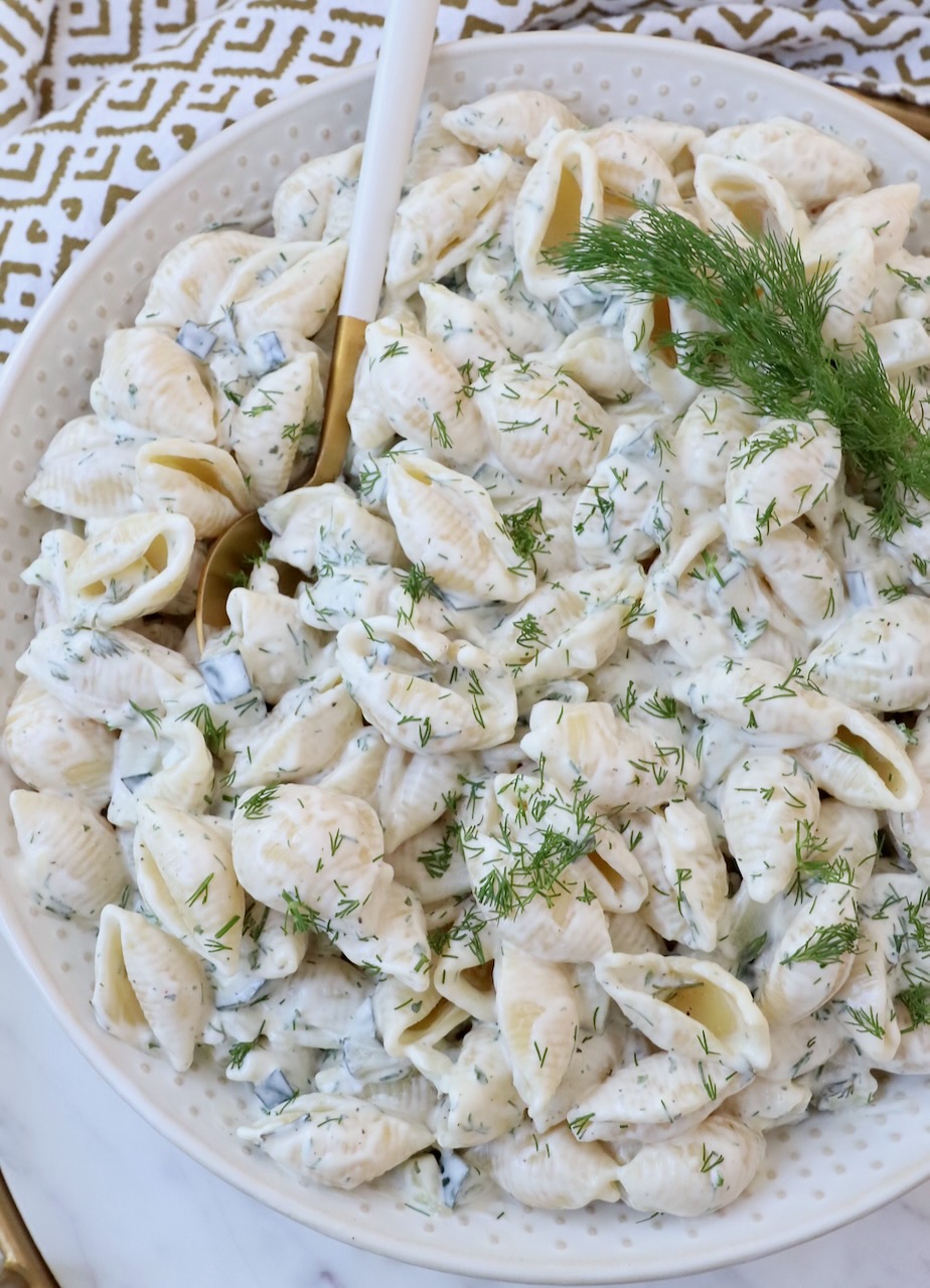 creamy pasta salad in bowl topped with fresh dill