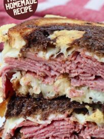 pastrami reuben sandwich cut in half and stacked up on plate