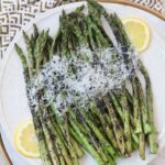 grilled asparagus on plate topped with parmesan cheese