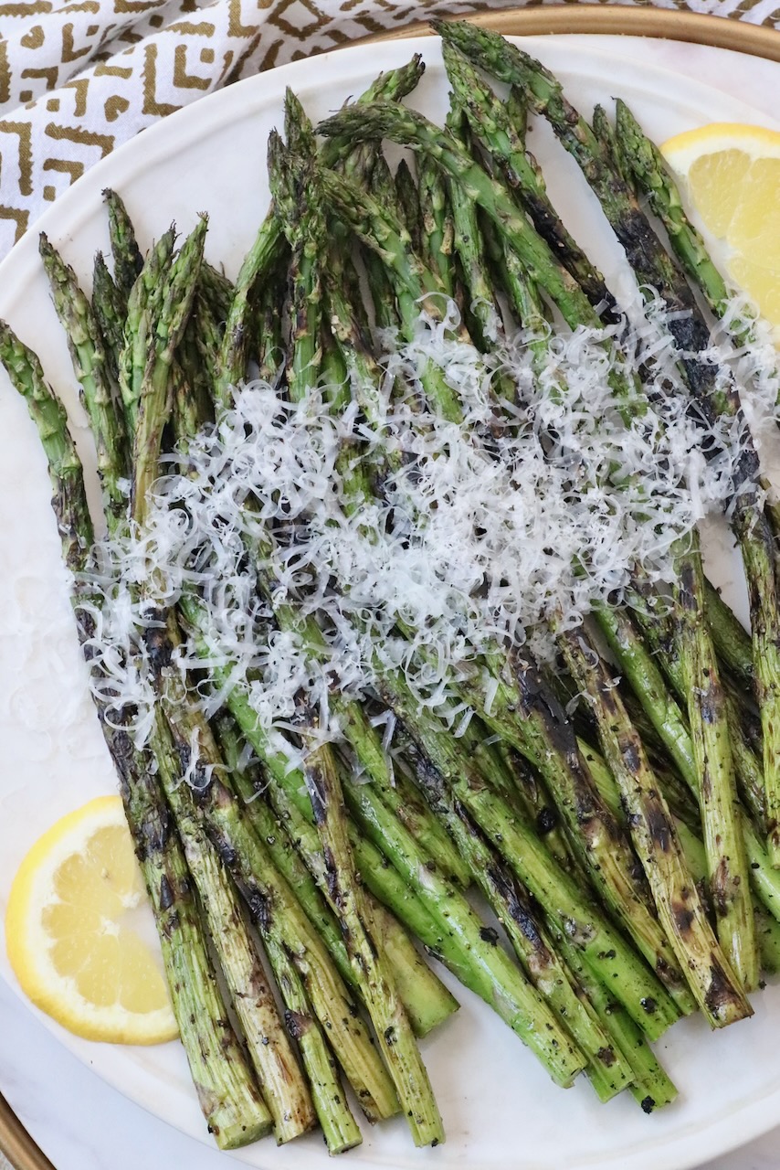 grilled asparagus topped with parmesan cheese on plate