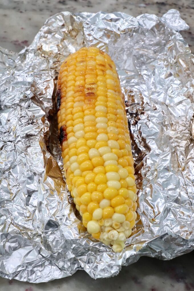 grilled corn on the cob on a piece of foil