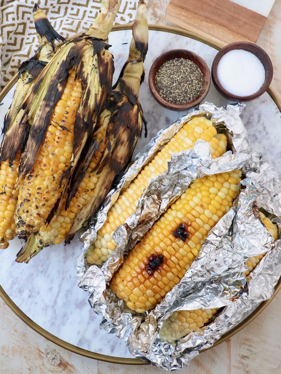 grilled corn on the cob on marble platter
