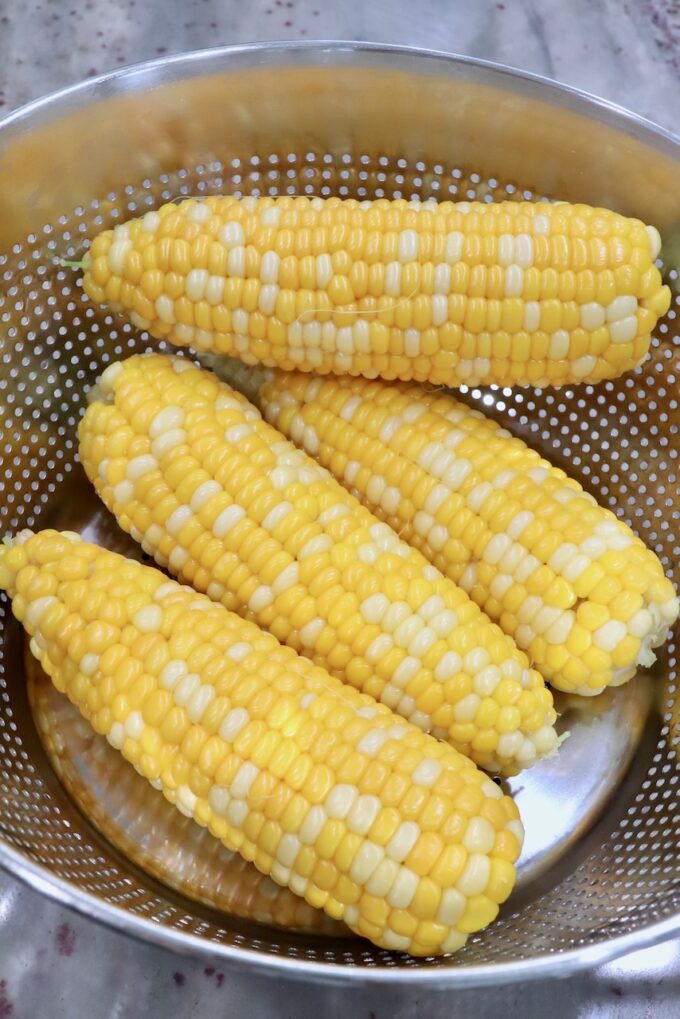 cooked corn on the cob in strainer