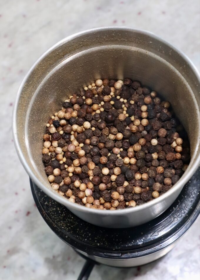 peppercorns, coriander seeds and mustard seeds in spice grinder