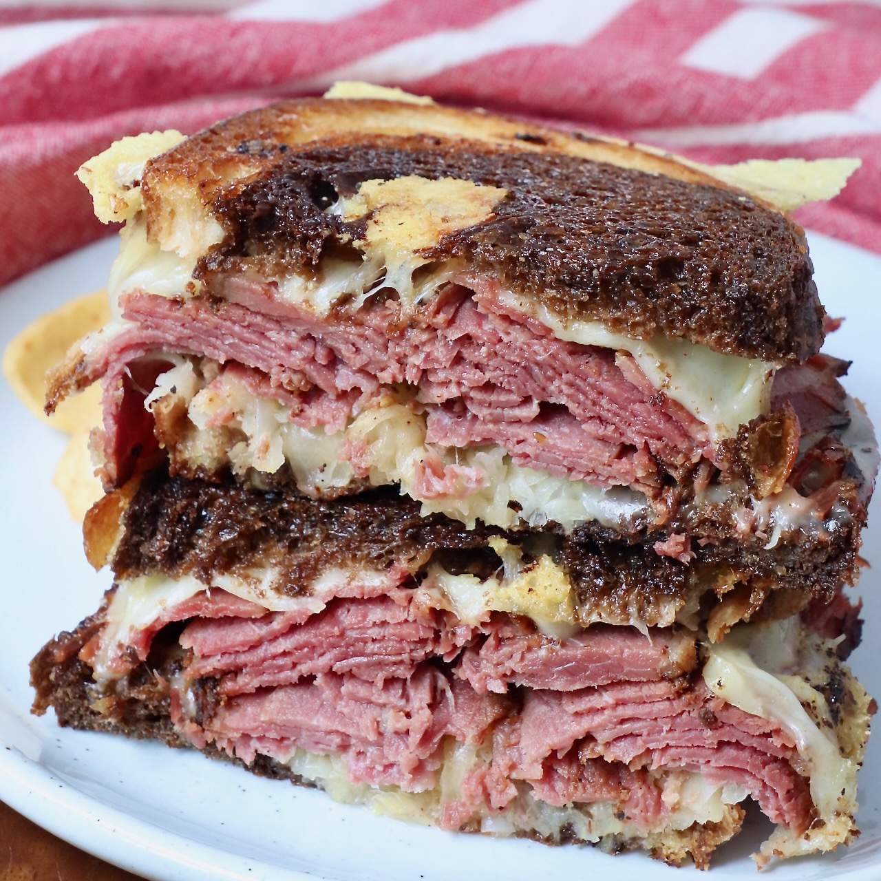 pastrami reuben sandwich cut in half and stacked up on plate