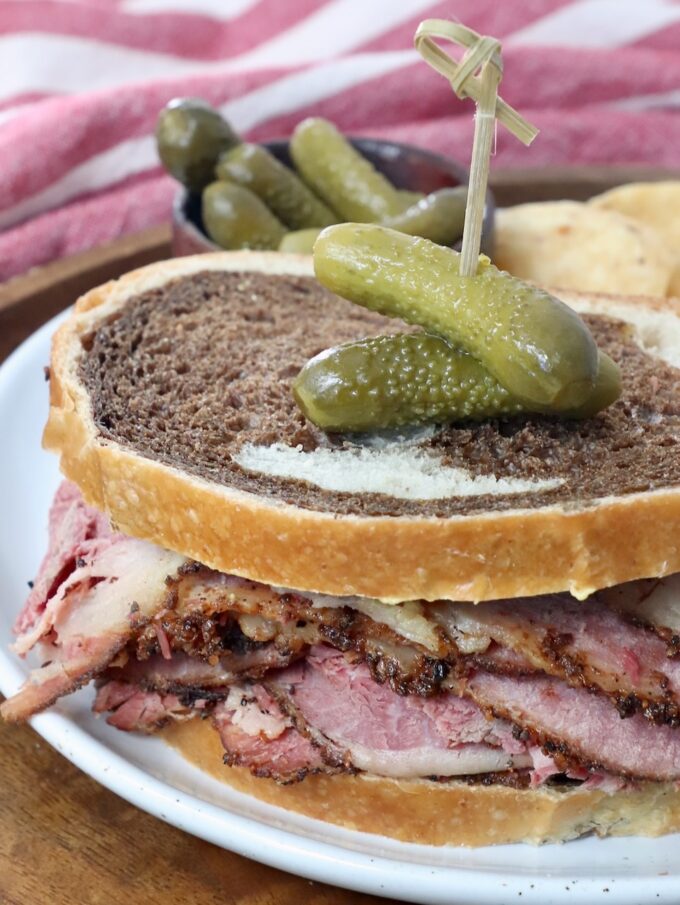pastrami sandwich on plate with cornichon pickles