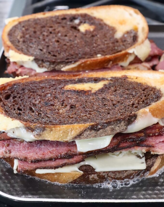 cooked pastrami reuben sandwiches on griddle