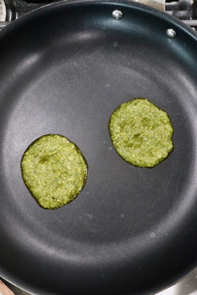 two scoops of basil pesto in skillet