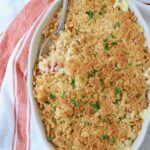 squash casserole in baking dish with serving spoon