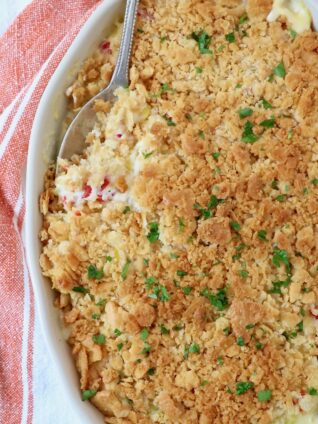 squash casserole in baking dish with serving spoon