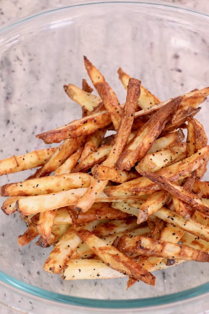 seasoned cooked french fries in glass bowl