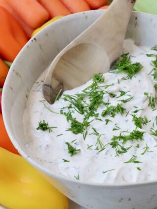 creamy vegetable dip in bowl topped with fresh chopped dill