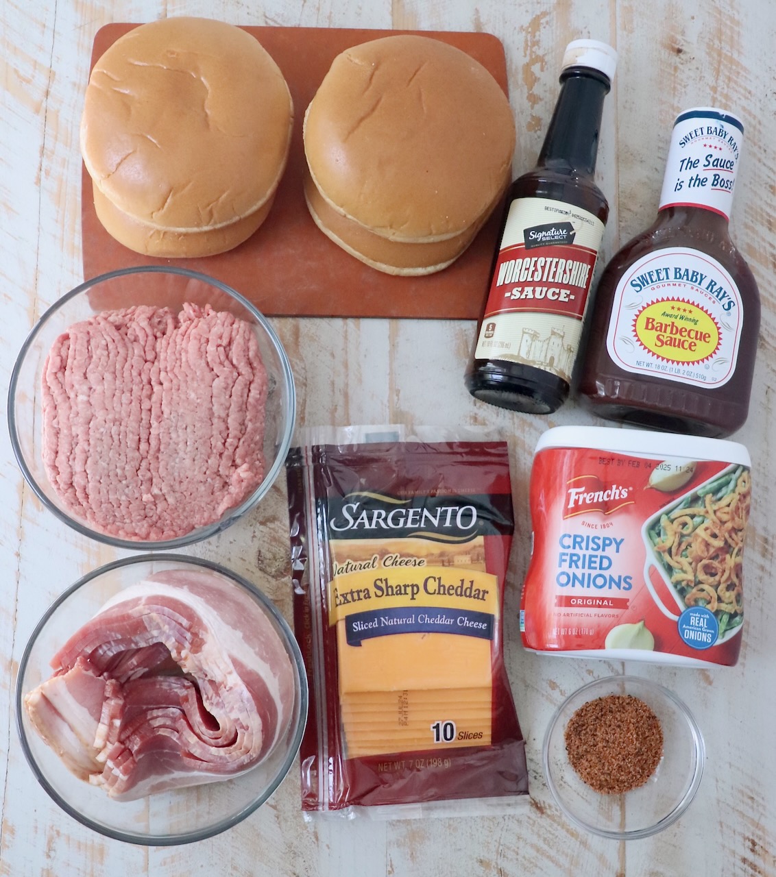 ingredients for bbq bacon burger on white wood board