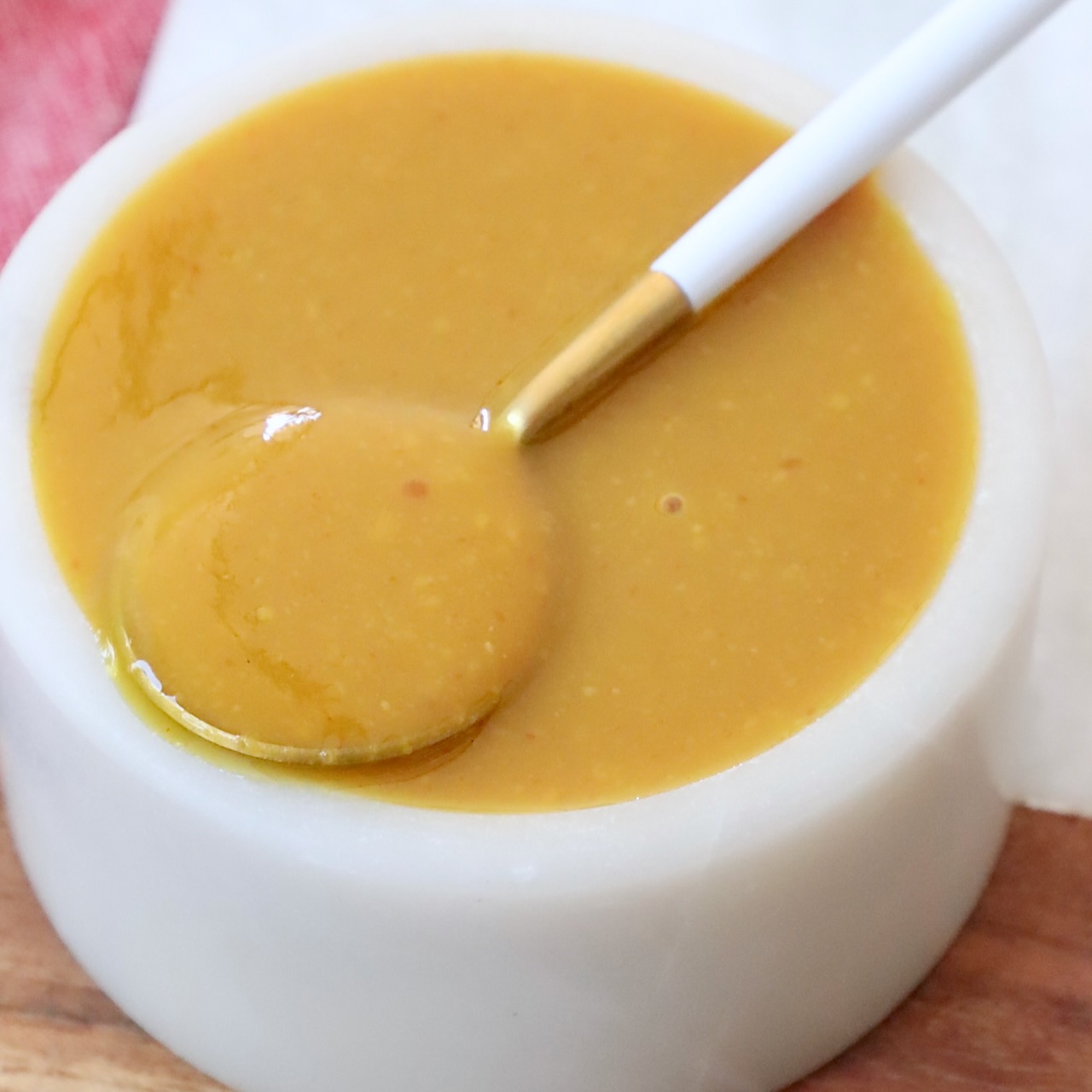 Carolina gold bbq sauce in small bowl with spoon