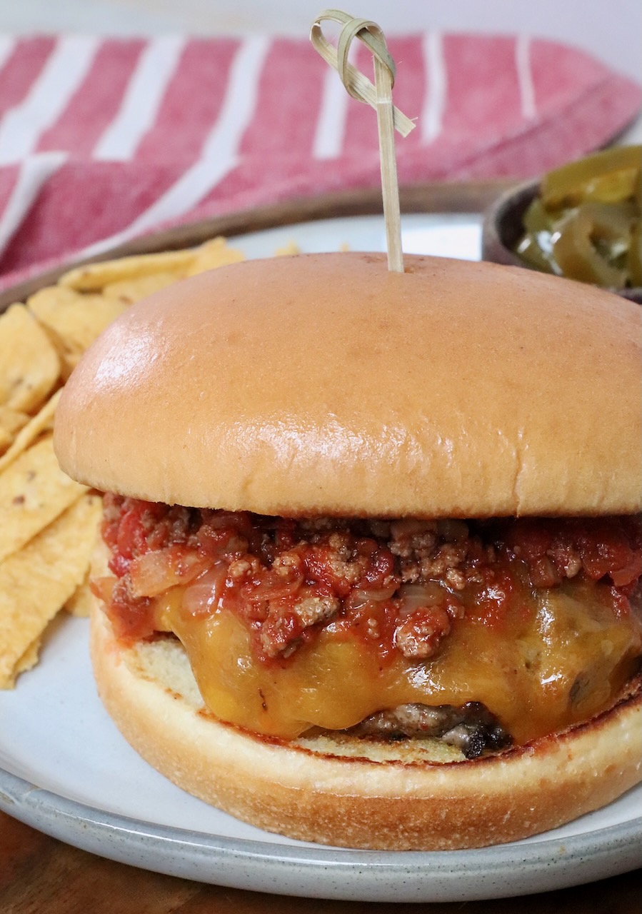 chili cheeseburger on plate with chips