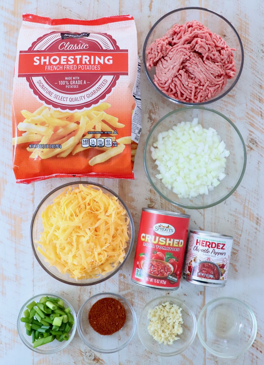 ingredients for chili cheese fries on white wood board