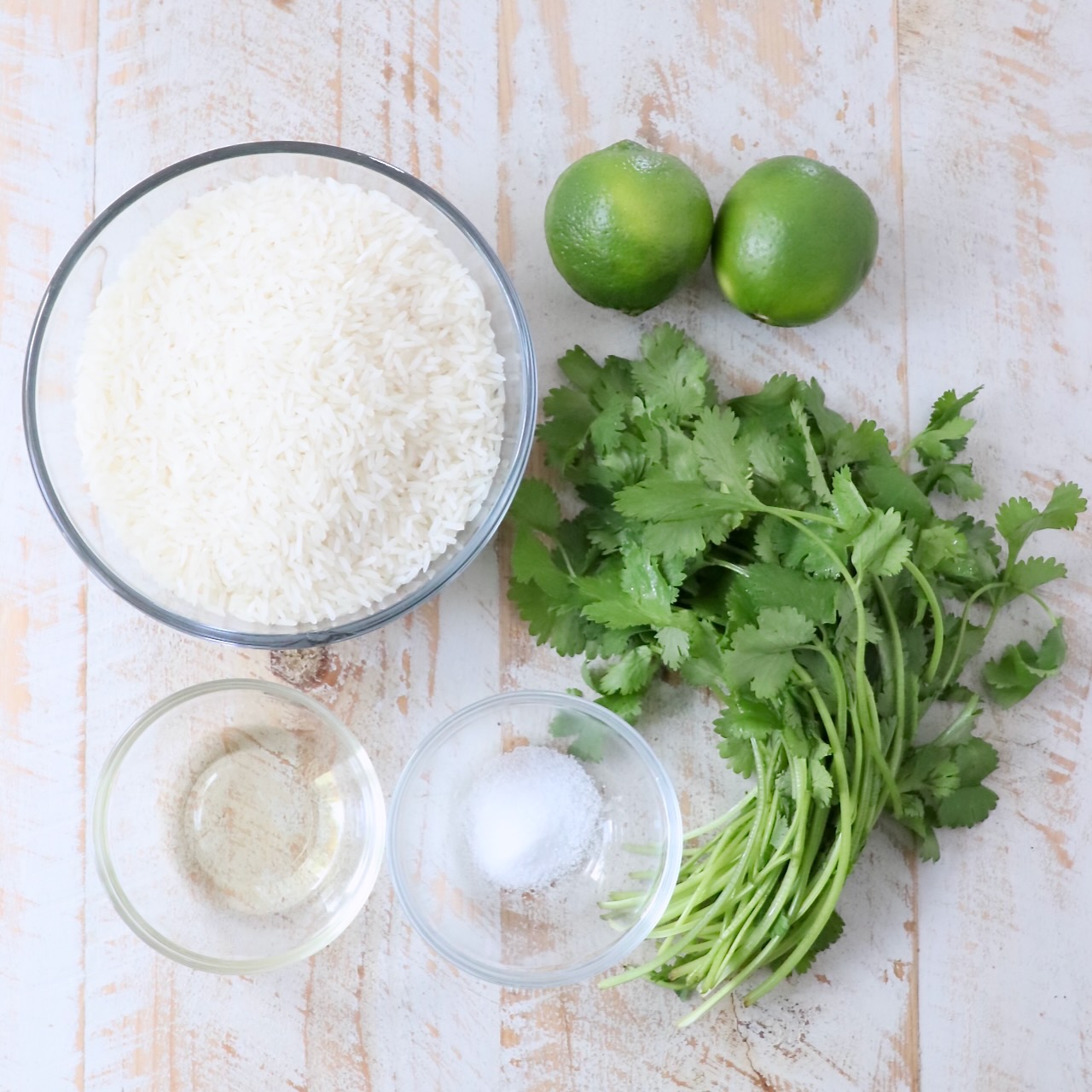 ingredients for cilantro lime rice on white wood board
