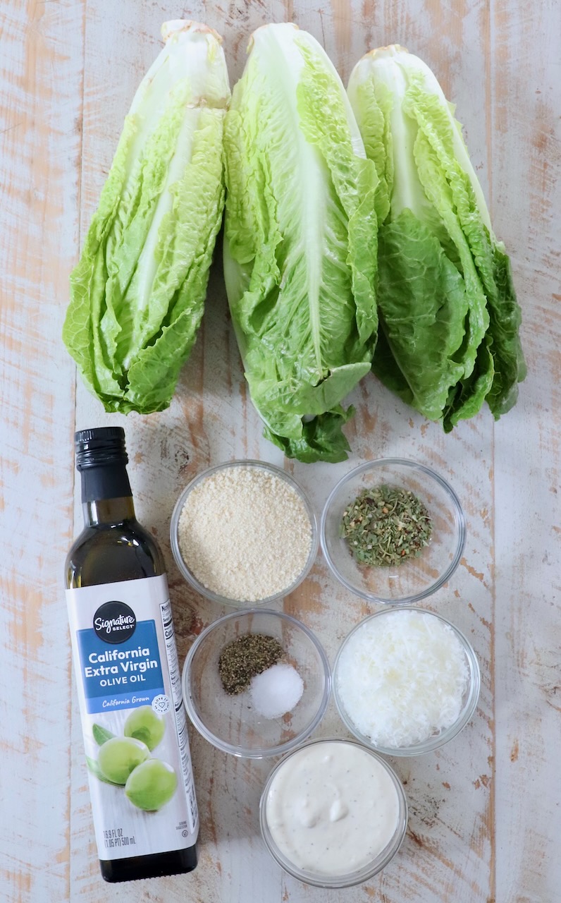 ingredients for grilled caesar salad on white wood board