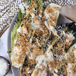 grilled romaine lettuce caesar salad on plate topped with toasted breadcrumbs