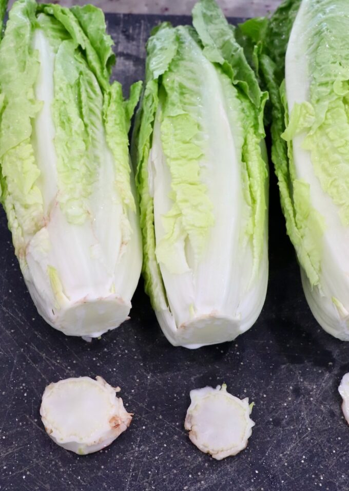romaine lettuce on cutting boards with the stems cut off