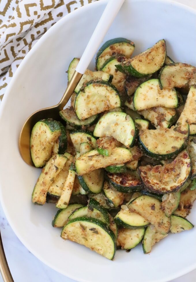 cooked sliced zucchini in bowl with serving spoon