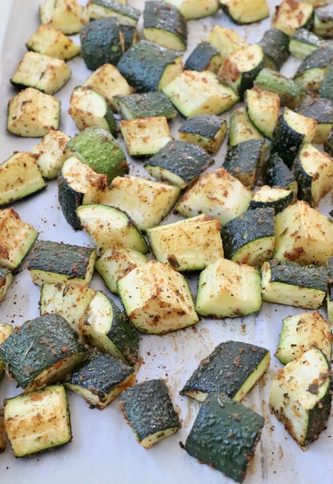 cooked diced zucchini on parchment lined baking sheet