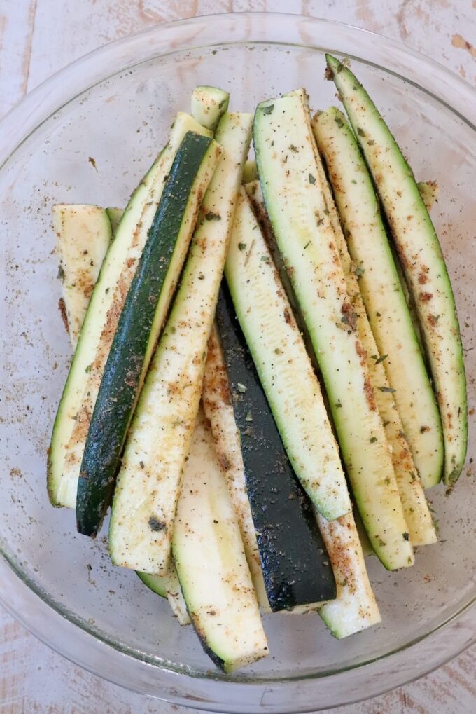 seasoned zucchini spears in large glass bowl