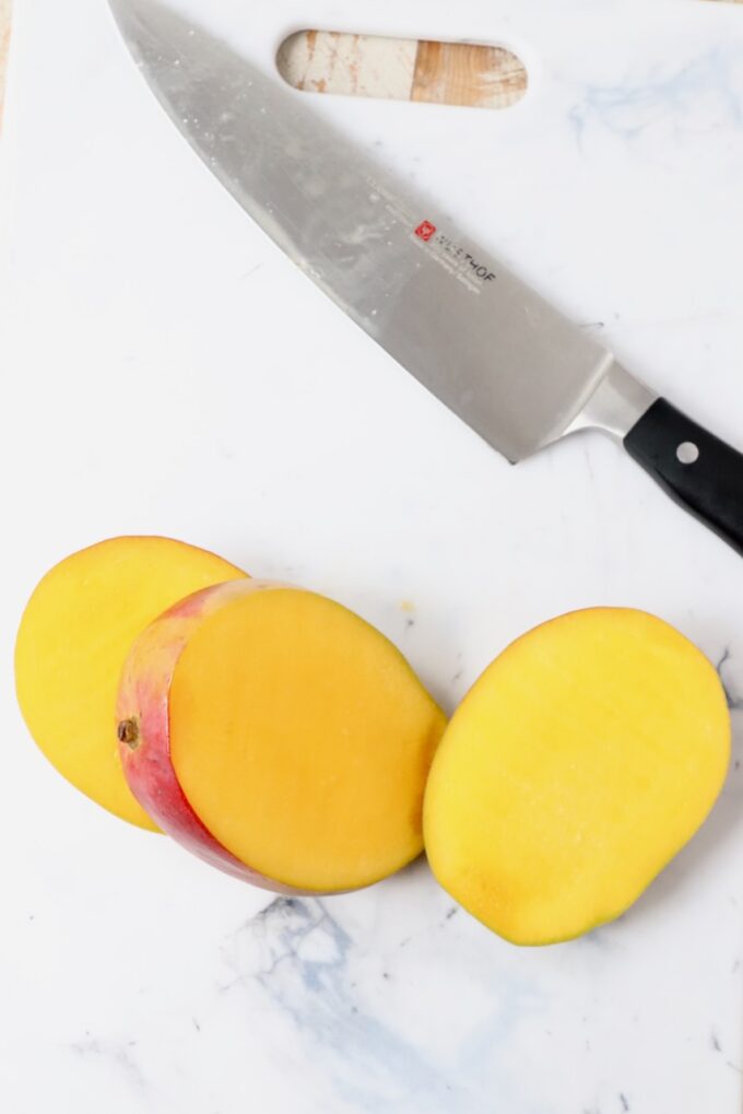 sliced mango on cutting board with knife