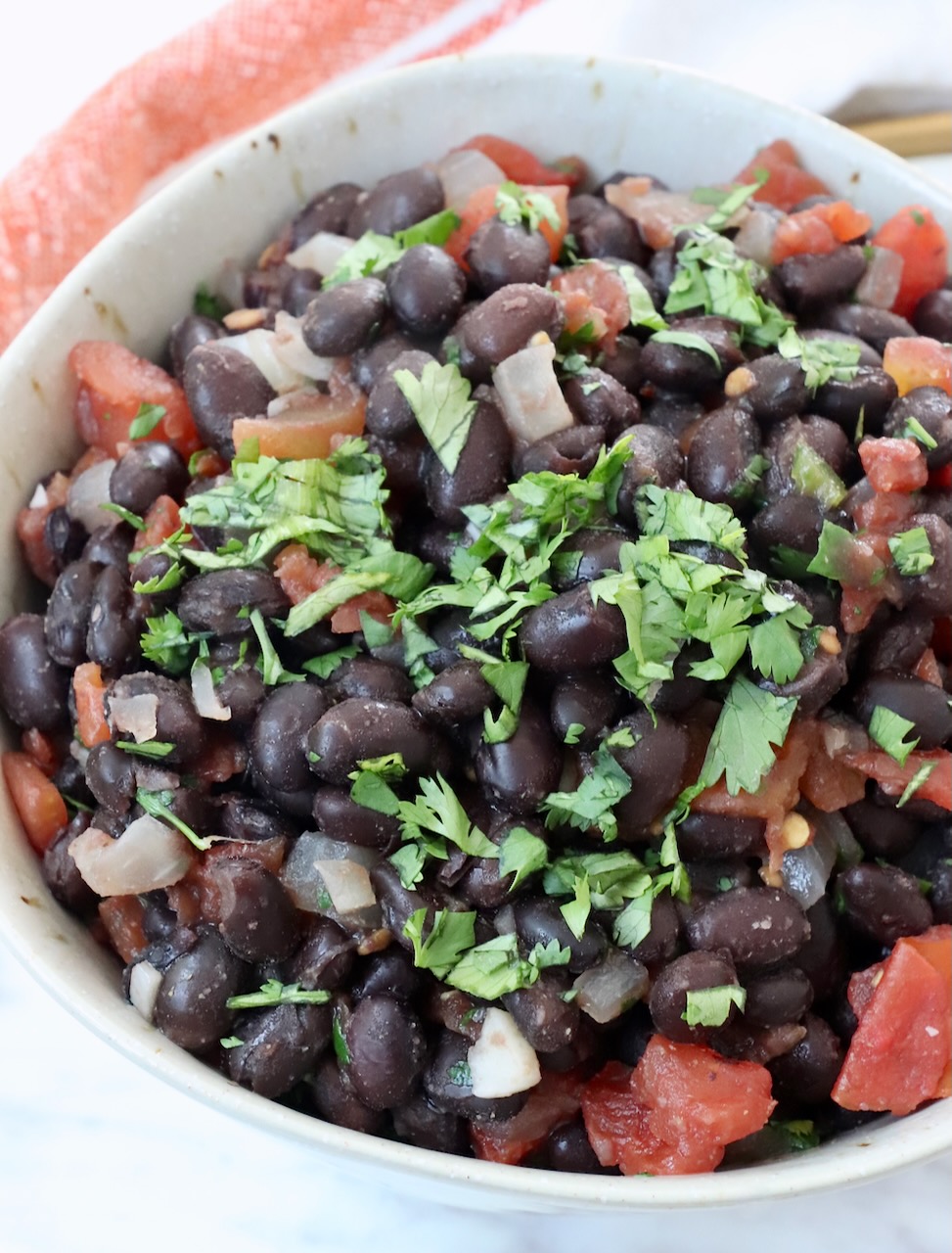 black beans and diced tomatoes in bowl topped with fresh cilantro