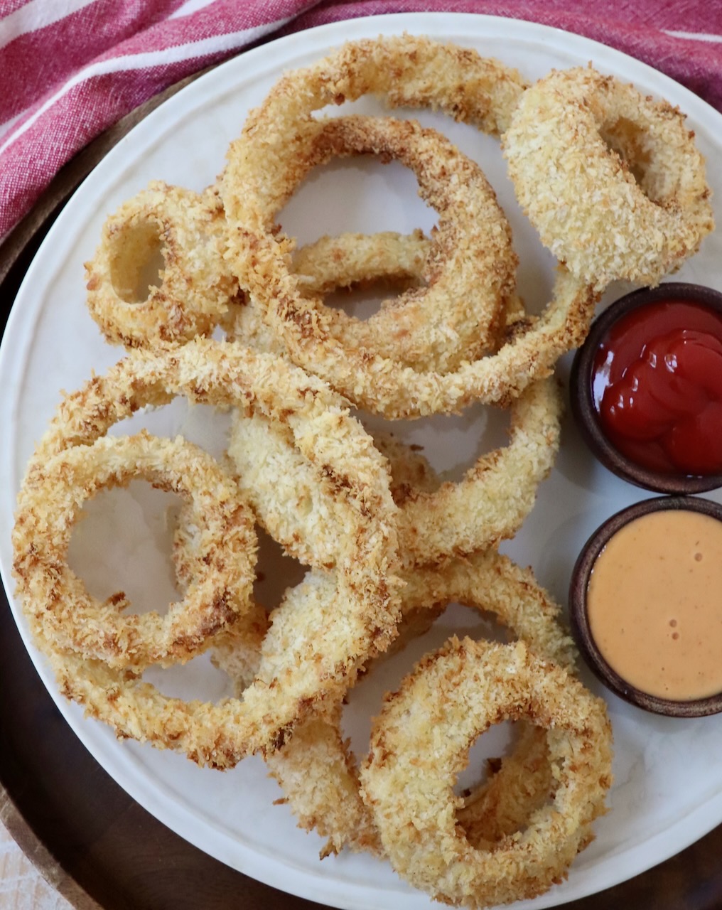 onion rings on plate with dipping sauces in small bowls on the side