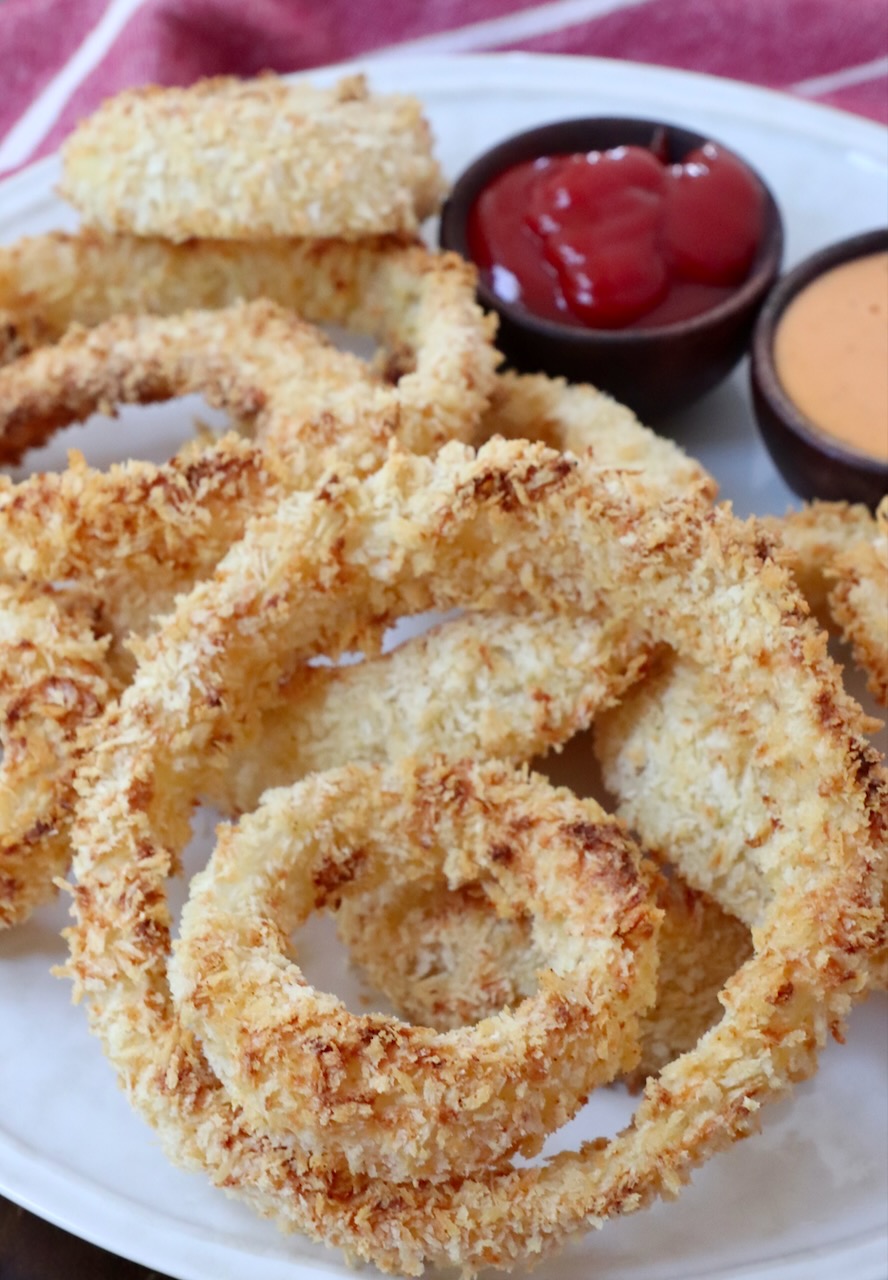 air fried onion rings on plate with small bowls of sauce on the side