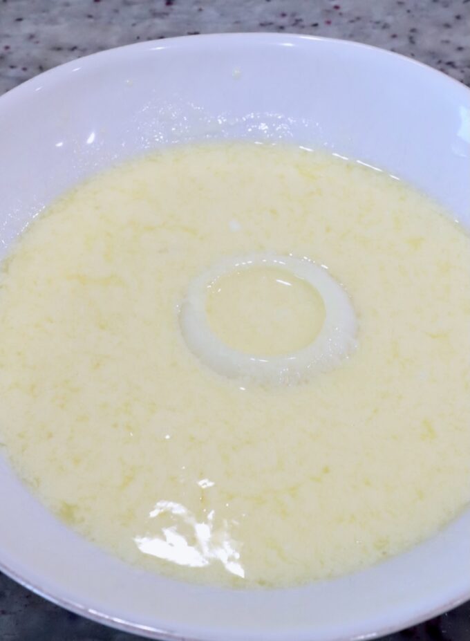 a slice of onion in a bowl of buttermilk