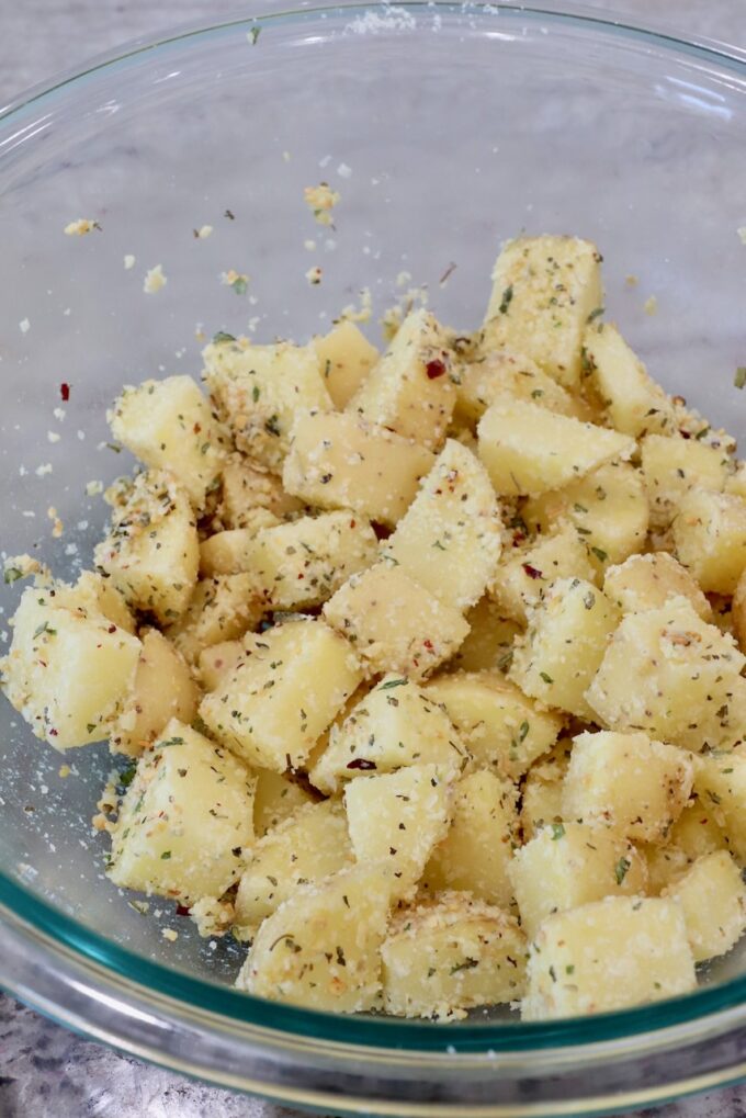 seasoned cubes of potatoes in a glass bowl