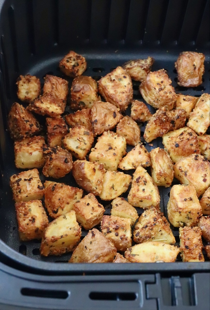 roasted cubed potatoes in an air fryer basket