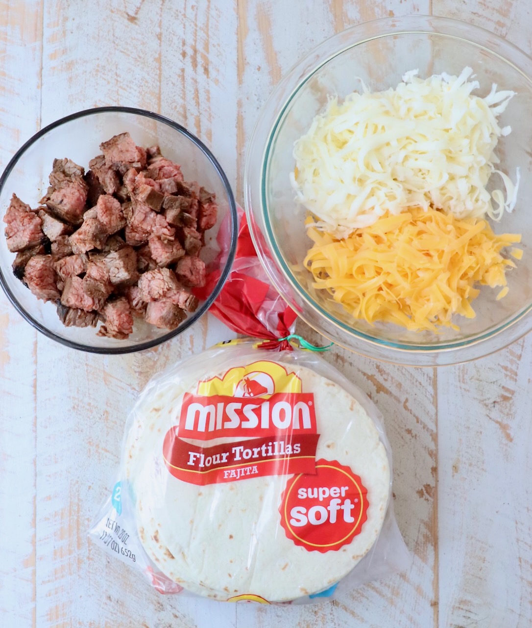 ingredients for beef taquitos on white wood board