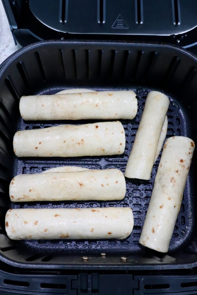 uncooked taquitos in air fryer basket