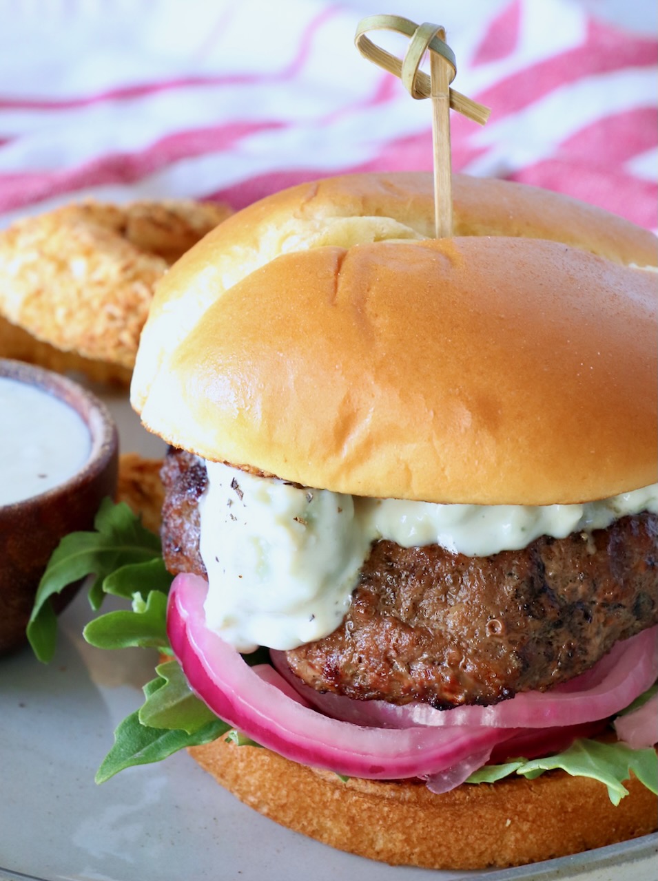 grilled burger on plate topped with blue cheese sauce