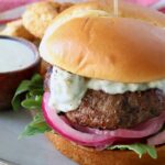 burger on plate with pickled onions and blue cheese