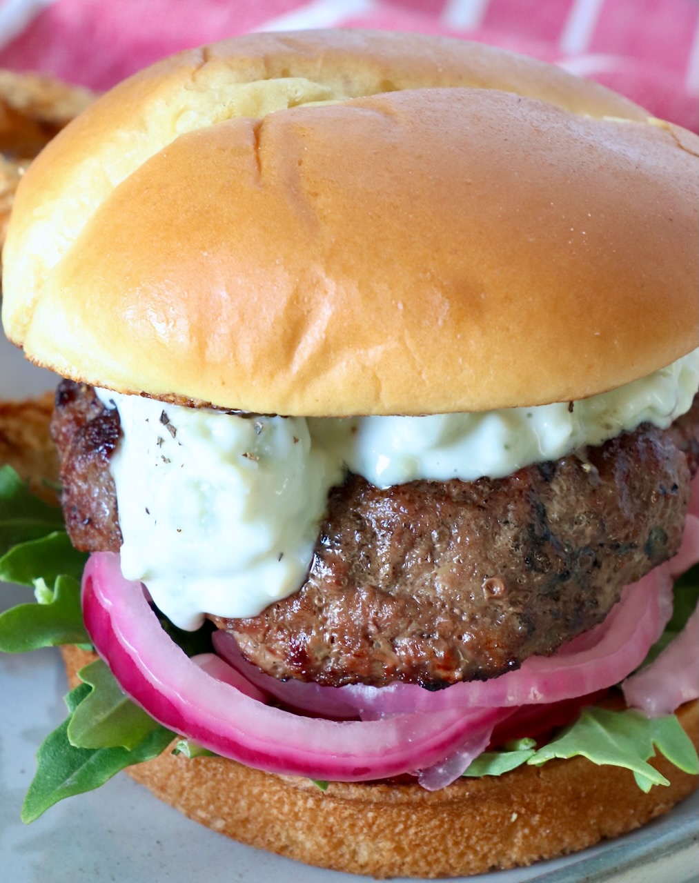 burger topped with blue cheese sauce on plate