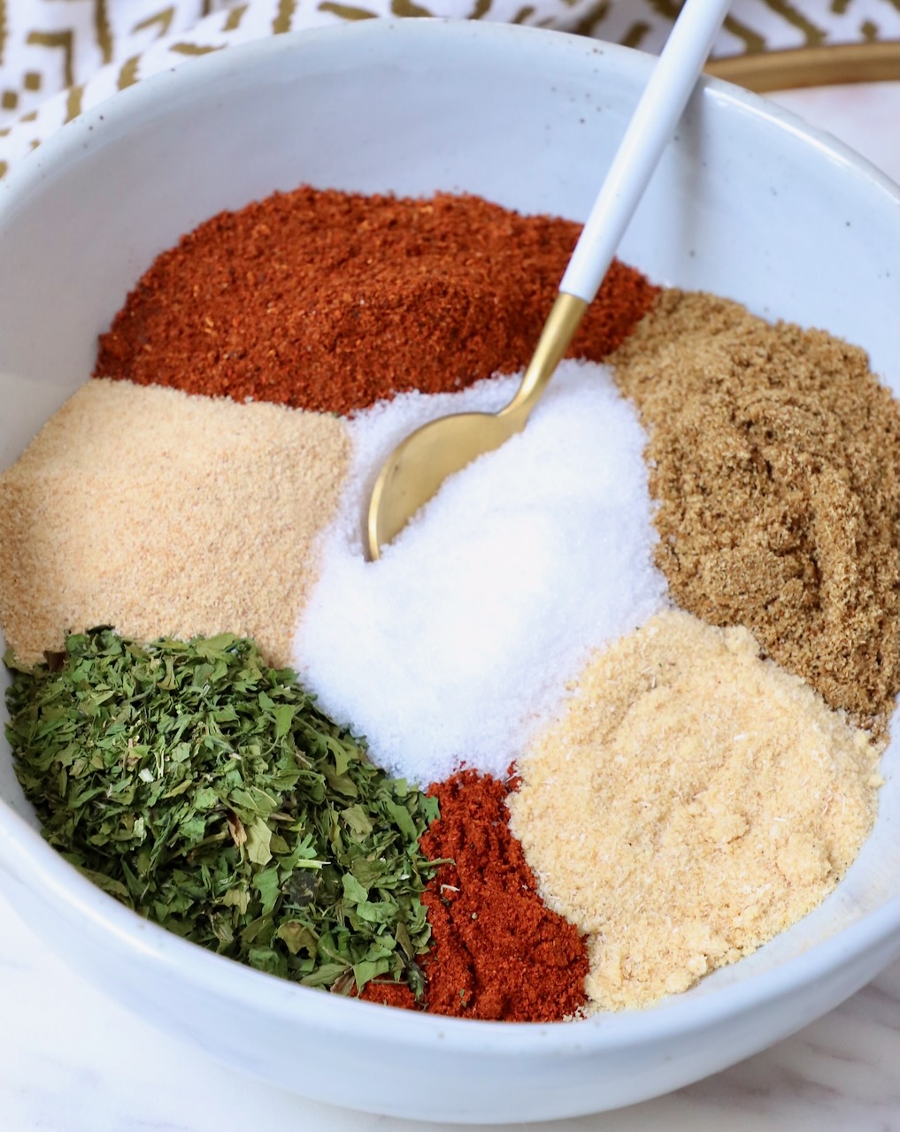 herbs and spices separated in bowl with spoon