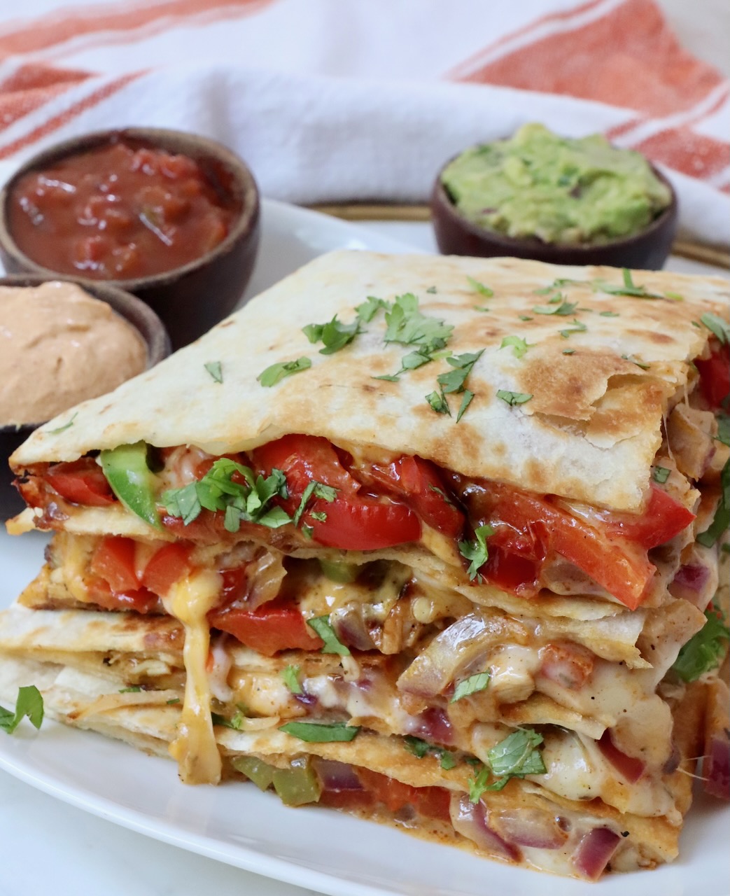 stacked up chicken and fajita veggie quesadilla on a plate