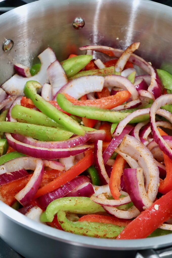 sliced bell peppers and onions in a pot