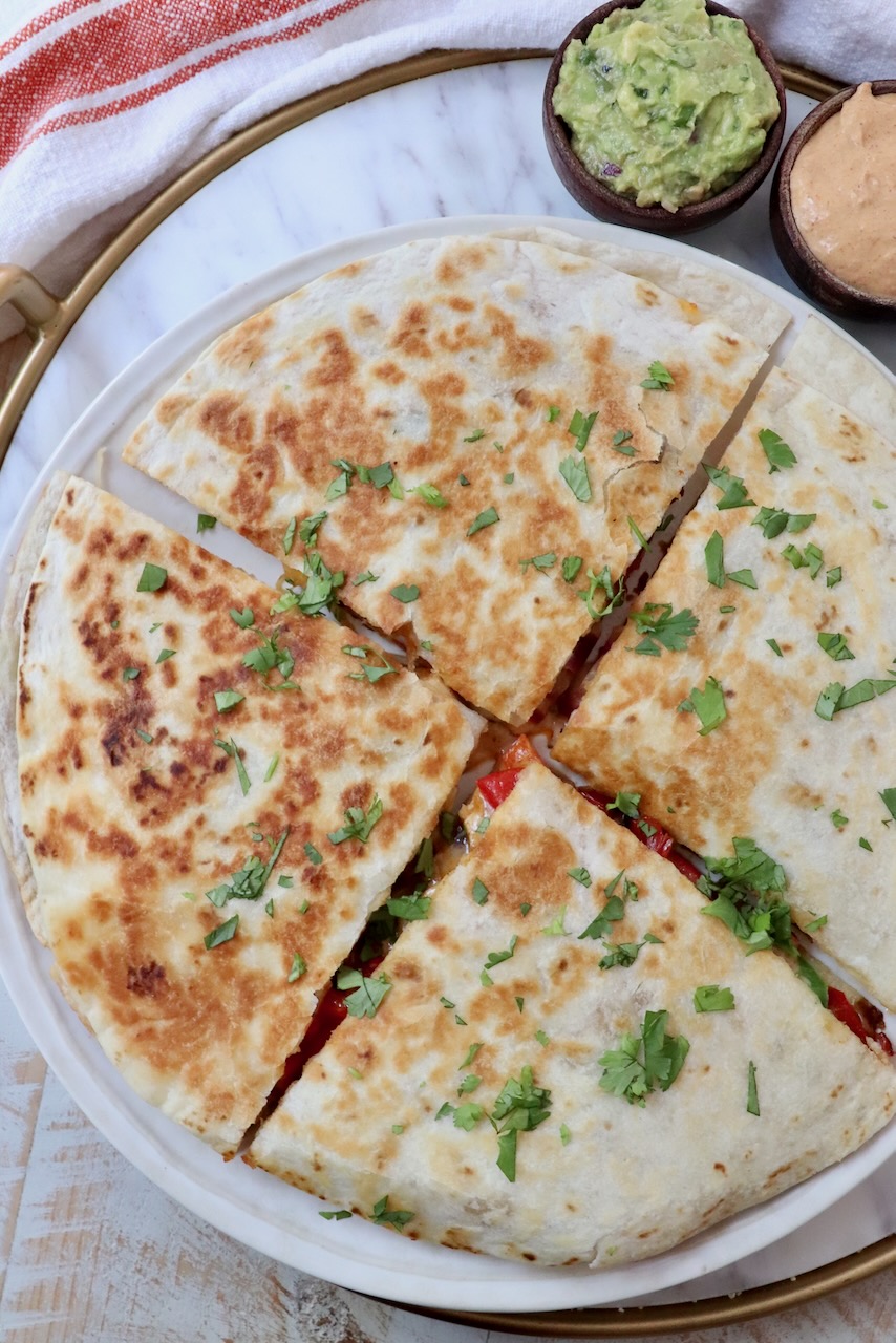 chicken quesadilla sliced into quarters on a plate