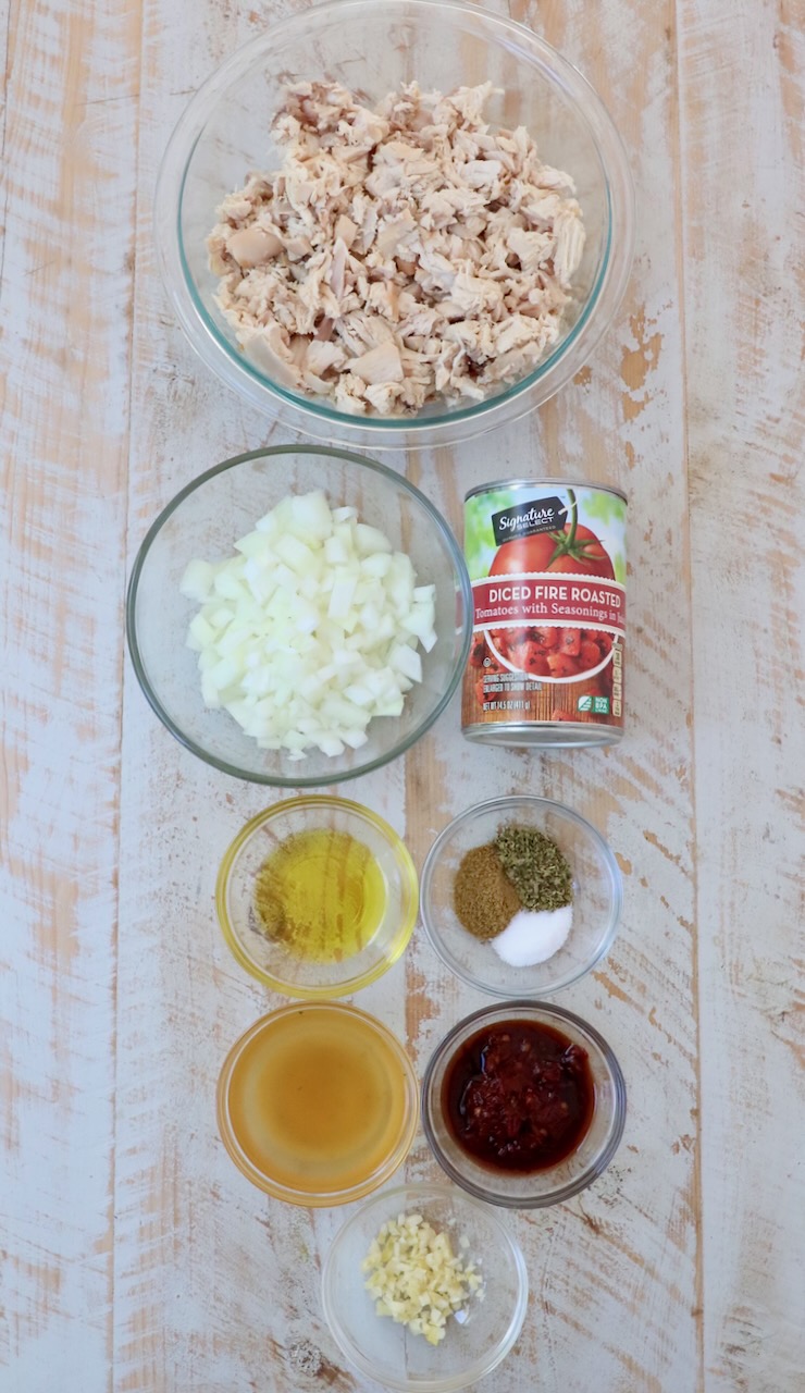 ingredients for chicken tinga on white wood board