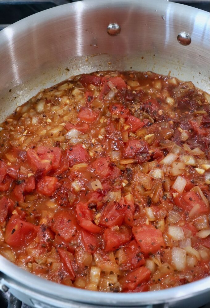 diced tomatoes in pan with diced onions, spices and chicken broth