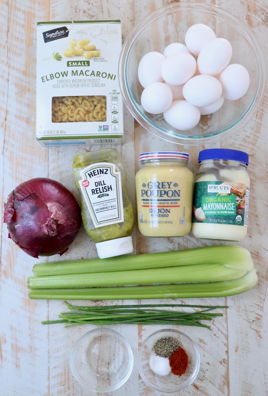 ingredients for deviled egg pasta salad on white wood board